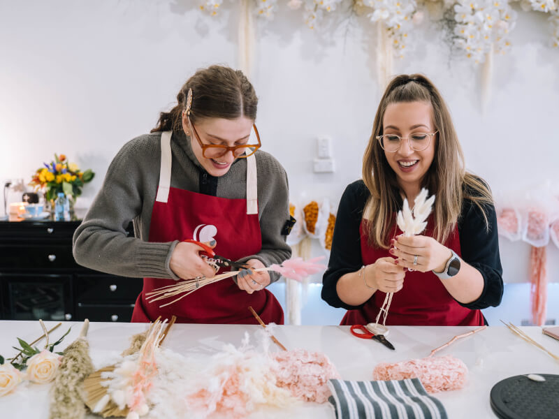 Two women making dried flower arrangements